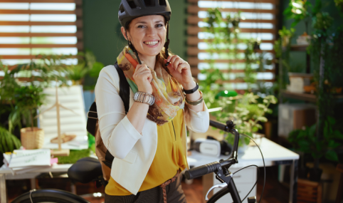 bike to work: Junge Frau setzt im Büro Velohelm auf